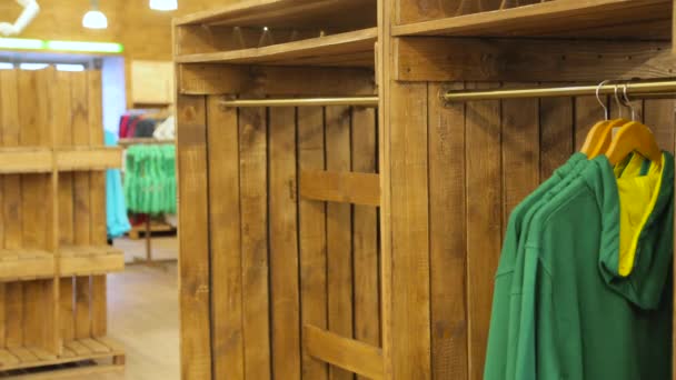 Перемещение одежды на вешалке в магазине — стоковое видео