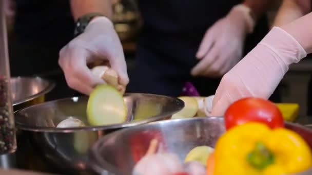 Повар кладет овощи в миску — стоковое видео