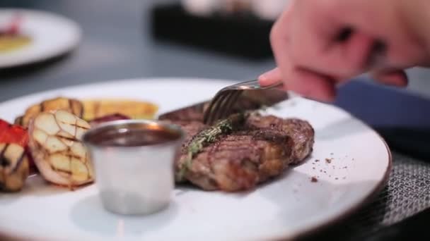 Homem cortando um bife no prato — Vídeo de Stock