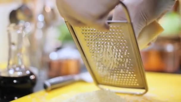 Шеф-повар растирает сыр пармезан — стоковое видео