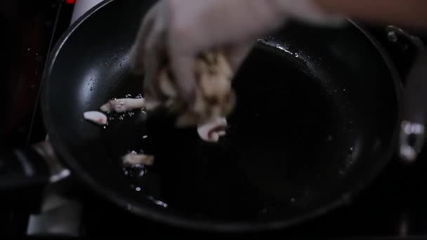 Шеф наливает грибы в сковородку. — стоковое видео