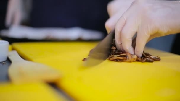 Шеф-кухар, що ріже смажені гриби крупним планом — стокове відео