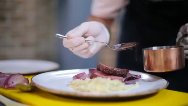 Шеф-повар украшает тарелку стейком — стоковое видео