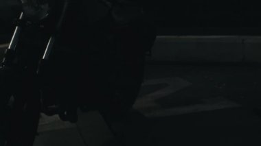 Bir adam gün doğumunda motosiklete biniyor.