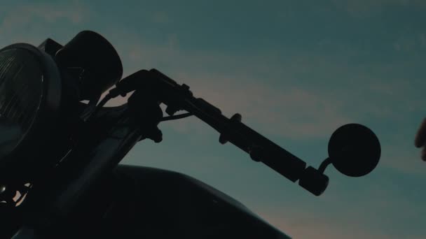Чоловік у шоломі сидить за мотоциклом — стокове відео