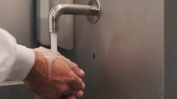 손이 닿지 않는 수돗물에 손을 씻는 사람 — 비디오