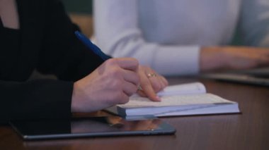 kız görüşmeler sırasında bir not defterine bilgi yazar