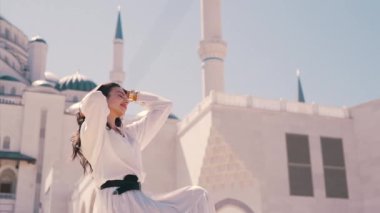 Güneşli bir günde caminin arka planında bir kız