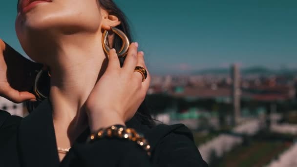 Girl demonstrates earrings on the background of the city — Stock Video