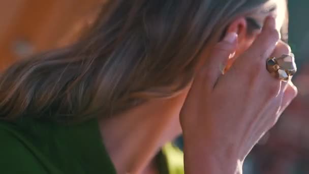 一个戴着金戒指的女孩在阳光灿烂的日子里抚摩着她的头发 — 图库视频影像