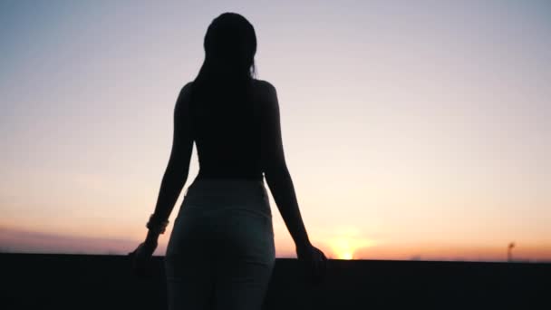 Dívka se dívá na západ slunce z výšky — Stock video