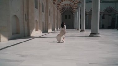 Bir kız eski bir caminin bölgesinde yürüyor.