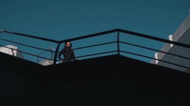 Mimarinin arka planında katı siyah elbiseli bir kız.