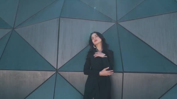 Девушка на фоне абстрактной стены — стоковое видео