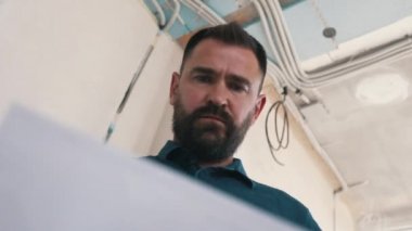 Mimar tesisteki çizimleri inceliyor.
