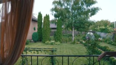 Kadın bahçesine bakıyor.