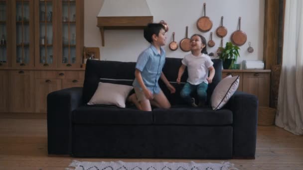 Kinder springen auf die Couch — Stockvideo