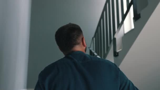 Мужчина поднимается по лестнице в жилом здании — стоковое видео
