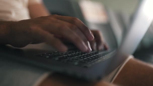 Un hombre trabajando en un portátil de rodillas — Vídeos de Stock