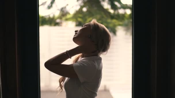Γυναίκα που αισθάνεται πόνο στο λαιμό στέκεται δίπλα στο παράθυρο — Αρχείο Βίντεο