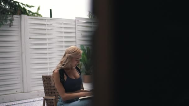 Спортивна дівчина читає книгу на задньому дворі — стокове відео