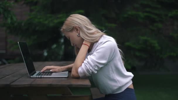 La chica sintió un dolor en el cuello mientras trabajaba en un ordenador portátil — Vídeo de stock