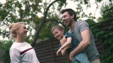 Yeşil bahçede eğlenen çocuklu bir aile.