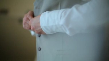 Adam onun yelek üzerinde kadar düğmelerini