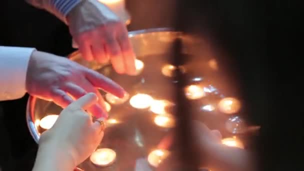 Люди кладуть маленькі свічки у воду — стокове відео
