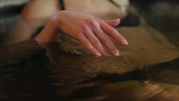 Chica en jacuzzi lleva la mano en el agua — Vídeos de Stock