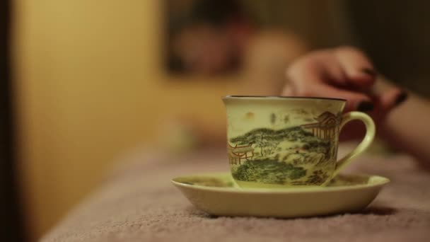 Девушка пьет чай из чашки с китайским узором — стоковое видео