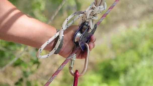 Man håller ett rep och fångster carabiner — Stockvideo