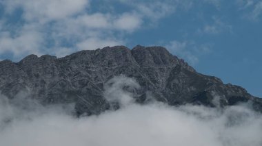 Mountain peak surrounded by clouds and blue sky