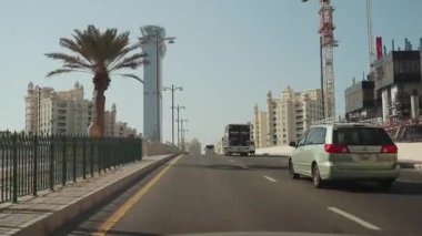 Urban Road with Traffic, Palm Trees, and Tall Skyscraper