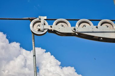 Metal makara sistemi açık mavi gökyüzüne karşı çalışıyor