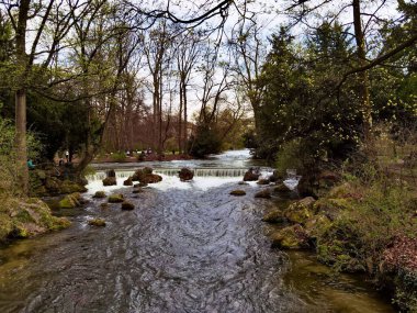 Ağaçlar ve kayalarla çevrili akan nehir.