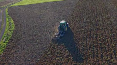 Green Tractor Plowing a Brown Field for Planting
