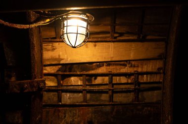 Kırsal ahşap tavan ve duvarı aydınlatan eski endüstriyel ışık.