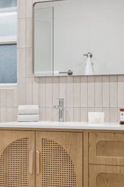 Ahşap dolap ve aynalı modern banyo.