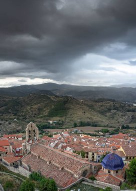 Tepelerin ve şehrin çatılarının üzerinde bulutlu bir gökyüzü