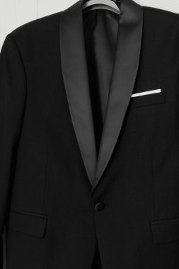 Black tuxedo jacket hanging on hanger