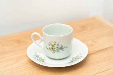 Hassas fincan ve çay tabağı masada.