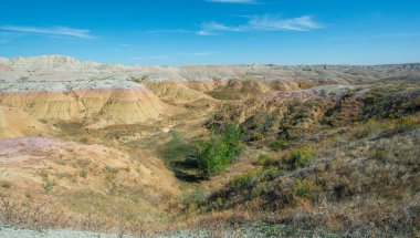 Vast landscape of rolling hills and vegetation under a clear blue sky