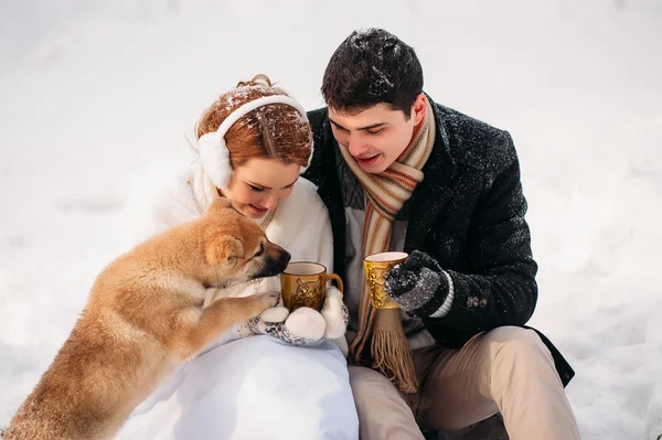 Pareja con un perro en el bosque de invierno — Foto de Stock