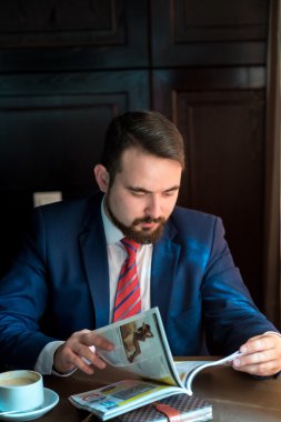 Kafe okuma dergisinde genç bir işadamı.