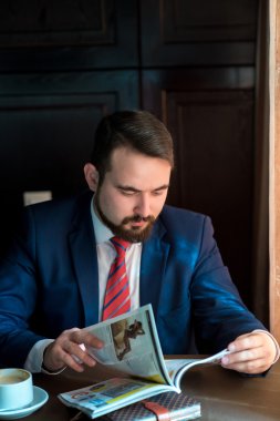 Kafe okuma dergisinde genç bir işadamı.