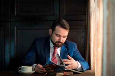 Kafe okuma dergisinde genç bir işadamı.