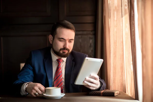 Erfolgreicher Geschäftsmann liest Nachrichten auf Tablet — Stockfoto