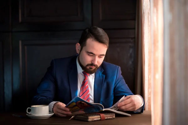 Jungunternehmer in einem Café, das Magazin liest — Stockfoto