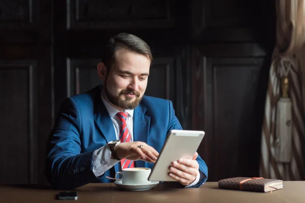 Joven empresario exitoso lee las noticias en la tableta Fotos de stock libres de derechos